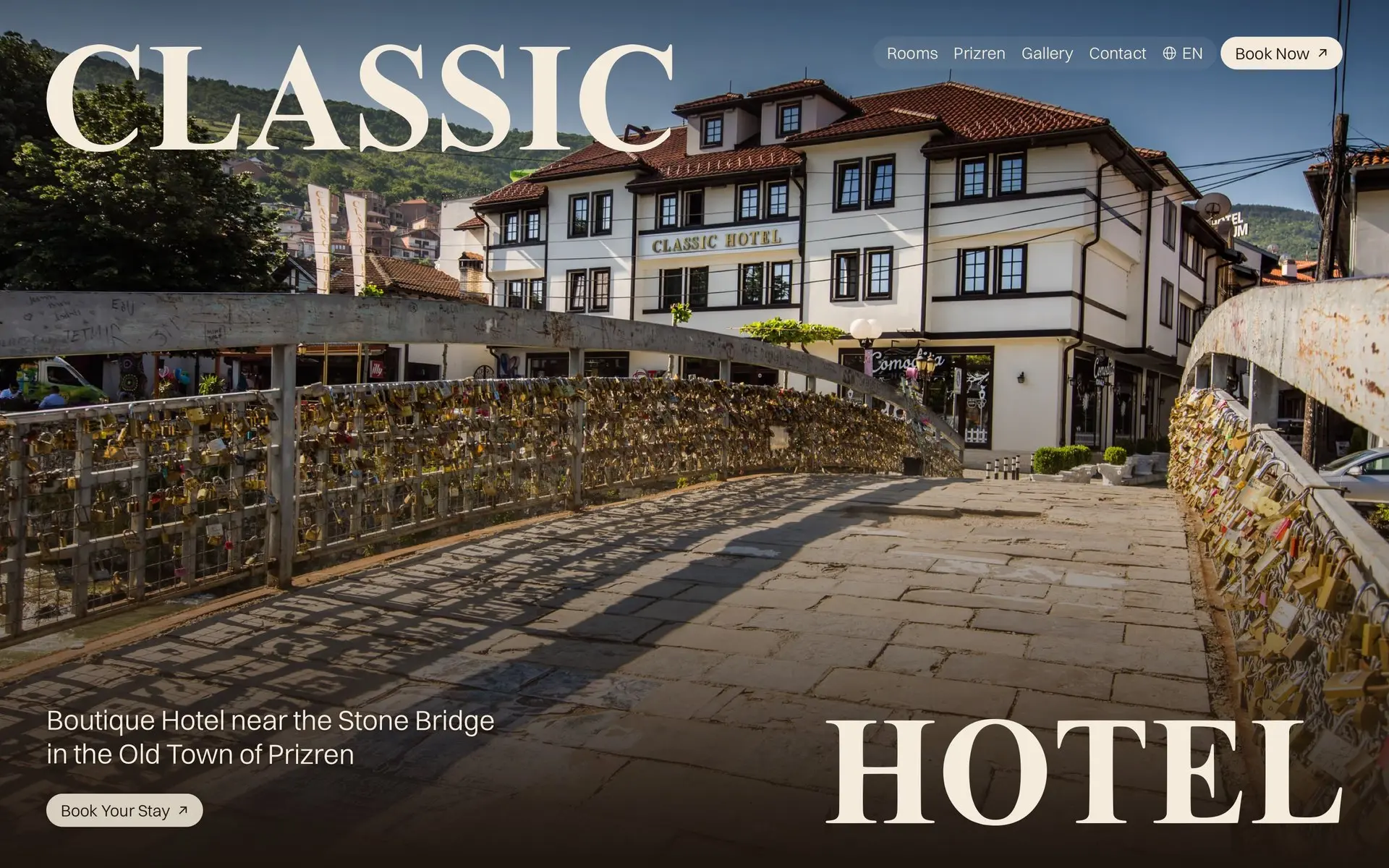 The Classic Hotel homepage: the words Classic and Hotel move apart to the corners while the photo of the hotel, beside a footbridge covered in padlocks, opens out of a rounded window